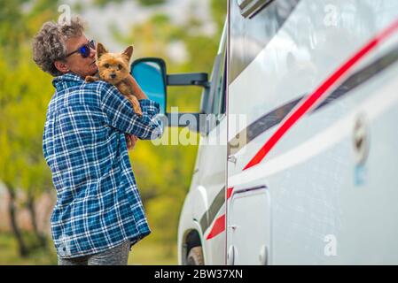 Pensionierte Frau auf der Road Trip mit ihrem kleinen australischen Silky Terrier Dog. Klasse C Wohnmobil. Sommerurlaub. Stockfoto