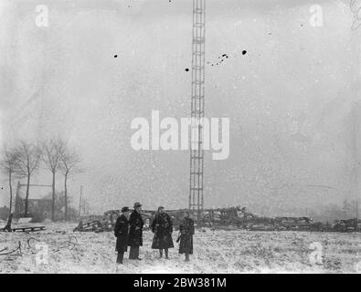 Zehn bei einem britischen Verkehrsflugzeug-Crash getötet. Acht Passagiere, der Pilot und der erste Offizier wurden getötet, als das Imperial Airways-Flugzeug, Apollo, von Brüssel nach London flog, in den Antennenmast des Ruysselde-Radiosenders in der Nähe von Brügge, Belgien stürzte und in Flammen aufbrach. Foto zeigt ; J F Van der Haeghen der Designer der Funkmasten , Inspektion der gebrochenen Mast . (Er ist mit Bart und schwarzem Hut gesehen). 31 Dezember 1933 Stockfoto