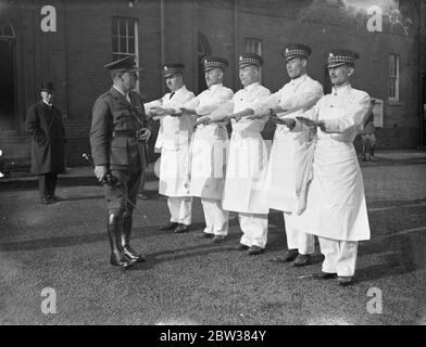 Teams, die jeweils aus einem Sergeant oder Superintending Koch, und vier Männer, konkurrierten in der 1934 Armee Kochen Wettbewerbe an der Armee Schule der Kochtei, Aldershot. Foto zeigt, Köche des 1. Battalion Schotten Guards mit ihren Händen inspiziert, bevor sie in Aktion im Wettbewerb. 13 März 1934 Stockfoto