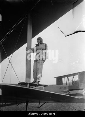 RAF Fallschirmtest Abschnitt bei der Arbeit . Eine Demonstration wurde an der Royal Air Force Fallschirmabteil am Henlow Aerodrome, Bedfordshire, der Arbeit und Ausbildung von Fallschirmspringer gegeben. Fallschirmspringen zu testen ist eines der Gegenstände, die der Öffentlichkeit am Empire Air Day 24. Mai zugänglich sind. Foto zeigt, ein Fallschirmspringer nimmt Position auf einer Sprungplattform, die am Flügelstrang eines Vickers 'Virginia' Fallschirmtrainingsflugzeugs hält. 10 Mai 1934 Stockfoto