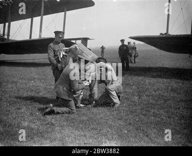 RAF Fallschirmtest Abschnitt bei der Arbeit . Eine Demonstration wurde an der Royal Air Force Fallschirmabteil am Henlow Aerodrome, Bedfordshire, der Arbeit und Ausbildung von Fallschirmspringer gegeben. Fallschirmspringen zu testen ist eines der Gegenstände, die der Öffentlichkeit am Empire Air Day 24. Mai zugänglich sind. Foto zeigt, ein Fallschirmspringer wird in seinen Fallschirm vor einem Vickers 'Virginia' Fallschirm Trainingsflugzeug geholfen. 10 Mai 1934 Stockfoto