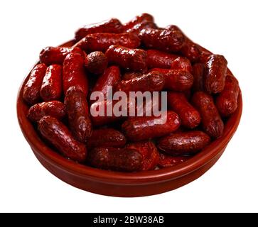 Heiße Mini-Chorizo-Würstchen in Keramikschale serviert. Beliebte spanische Vorspeise für Rotwein. Isoliert auf weißem Hintergrund Stockfoto