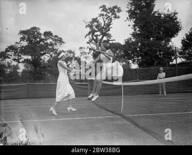 Jugendliche Tennis-Stars treffen sich in Wimbledon , um nationalen Titel zu entscheiden. Es gab einen Rekord-Eintrag für die British National Junior Lawn Tennis Championships, die in Wimbledon eröffnet. Foto zeigt, Miss A Pierrspont springen über das Netz, um Miss P Astbury nach ihrem Spiel gratulieren. 10. September 1934 Stockfoto