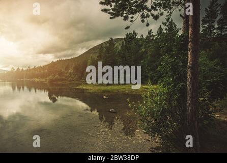 Landschaftlich schöner See irgendwo in Norwegen. Ruhiger Platz im Freien mit norwegischer Landschaft. Sauberes Wasser, Waldgrenze und die Berge. Stockfoto