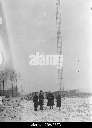 Zehn bei einem britischen Verkehrsflugzeug-Crash getötet. Acht Passagiere, der Pilot und der erste Offizier wurden getötet, als das Imperial Airways-Flugzeug, Apollo, von Brüssel nach London flog, in den Antennenmast des Ruysselde-Radiosenders in der Nähe von Brügge, Belgien stürzte und in Flammen aufbrach. Foto zeigt ; J F Van der Haeghen , der Designer des Mastes , Inspektion der gebrochenen Mast . (Er ist mit Bart und schwarzem Hut gesehen). 31 Dezember 1933 Stockfoto