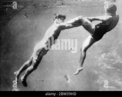 Beobachten Sie einen Lebensretter bei der Arbeit . Einer von einer Reihe von spannenden unter Wasser Bilder von der Red Cross Society of America gemacht, um lebensrettende Methoden zu demonstrieren, bei Silver Springs, Florida, ein Ort für sein klares Wasser bekannt. 25 Juli 1935 Stockfoto