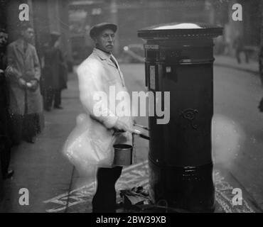 GPO 's einzige Mitarbeiter Säule Box Maler tritt nach 48 Jahren Dienst. Der einzige ständige Säulenmaler, der jemals bei der Post beschäftigt war, Herr Alfred H West of Tottenham, zieht sich an seinem 70. Geburtstag in den Ruhestand. Herr West hat Malerei London Pfeiler Boxen für 48 Jahre und berechnet, er hat fast gemalt 40,000 . Herr West bei der Arbeit an einem Londoner Pfeiler-Kasten . August 1937 Stockfoto