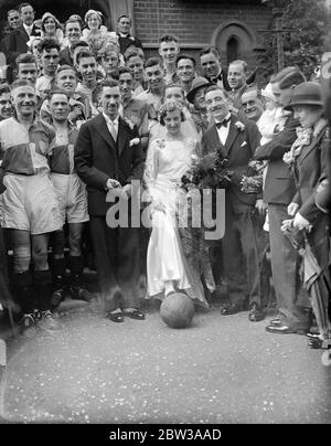 Fußballer ' Torbogen der Eckfahnen bei Teddington Hochzeit . Fußballer boten eine Ehrenwache, als Alfred J Phillips mit Miss Winifred Smith in der Teddington Methodist Church verheiratet war. Herr Phillips ist seit 14 Jahren Sekretär des Blackmores Sports Club und seit 12 Jahren Sekretär des Teddington Hospital Football Club. Die Braut und der Bräutigam verließen die Kirche durch einen Torbogen mit Eckfahnen. Foto zeigt die Braut und Bräutigam. 14. April 1934 Stockfoto