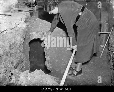 Überreste der römischen Mauer und gut in Barnett High Street gefunden. Entdeckungen von erheblicher Bedeutung für die archäologische Welt wurden an der Rückseite einer Drapery Einrichtung in High Street Barnett gemacht. Arbeiter in Ausgrabungsarbeiten für die Fundamente zu legen, entdeckt eine römische Feuersteinwand, 28 Meter lang, und ist in ähnlicher Weise zu den römischen Mauern bei St Albans entdeckt gebaut. In der Nähe einer der Wände wurde eine überdachte Wand 27 Meter tief ausgegraben. Eine Frau, die die römische Mauer entdeckt in Barnett. 15 Juni 1934 Stockfoto