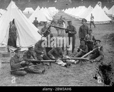 Armee inszeniert große Manöver auf Salisbury Plain . Die 23. Feldbrigade Royal Artillery kehrte nach einem Angriff auf die ' Westland Truppen ' unter dem Kommando von Brigadier W Green ins Lager zurück. Sie stehen unter dem Kommando von Brigadier A F Brooke, der die Eastland-Truppen kontrolliert. Sofort nach ihrer Rückkehr, Soldaten der 23. Feldbrigade gereinigt das Lager und die Waffen. Foto zeigt Soldaten der 28. Feldbrigade Royal Artillery Reinigung ihrer Waffen, mit Reihen von Zelten im Hintergrund. 12. September 1934 Stockfoto