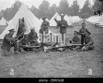 Armee inszeniert große Manöver auf Salisbury Plain . Die 23. Feldbrigade Royal Artillery kehrte nach einem Angriff auf die ' Westland Truppen ' unter dem Kommando von Brigadier W Green ins Lager zurück. Sie stehen unter dem Kommando von Brigadier A F Brooke, der die Eastland-Truppen kontrolliert. Sofort nach ihrer Rückkehr, Soldaten der 23. Feldbrigade gereinigt das Lager und die Waffen. Foto zeigt Soldaten der 28. Feldbrigade Royal Artillery Reinigung ihrer Waffen, mit Reihen von Zelten im Hintergrund. 12. September 1934 Stockfoto