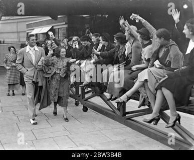 Bewundererinnen jubeln mexikanische Schauspielerin, Lupe Velez und ihr Mann, der amerikanische Schauspieler Johnny (Tarzan) Weismuller in Paddington Station. 5. Oktober 1934 . Stockfoto