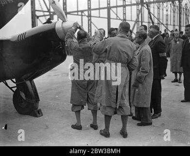 Der Prince of Wales inspiziert die Maschine für das London to Melbourne Air Race. Die De Havilland DH.88 Comet ' Grosvenor House ' , ein zweimotoriger britischer Flugzeug gemalt Scharlach . G-ACSS war Eigentum von Mr. A O Edwards und sollte im Rennen verwendet werden. 19. Oktober 1934 Stockfoto