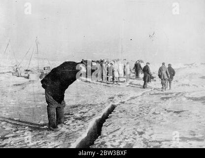 SS Chelyuskin, ein sowjetisches Dampfschiff, das auf einer Expedition durch Polareis entlang der nördlichen Seeroute von Murmansk nach Wladiwostok navigieren geschickt wurde, ist während der Navigation in arktischen Gewässern eisgebunden. Im September wurde er in den Eisfeldern gefangen. Danach trieb sie in der Eisschicht, bevor sie am 13. Februar 1934 in der Nähe der Koljuchin-Insel im Tschuktschen Meer niederging. Die Besatzung gelang es, auf das Eis zu entkommen und baute eine provisorische Flugbahn mit nur wenigen Spaten, Eisschaufeln und zwei Brechstangen, die bei der Rettung der Besatzung geholfen. 53 Männer gingen hinüber Stockfoto