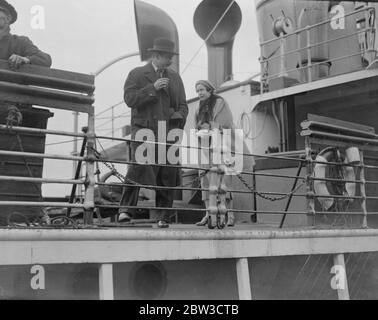 Sie segelten mit der Aquitania, ungewollt. Mr und Mr und Miss Gillin waren zwei unwillige Passagiere auf der Aquitania, als sie von Southampton aus nach New York segelte. Abschied von ihrem Vater, Herr John E Gillis, sie übersehen die Zeit und segelte mit dem Schiff. Sie wurden mit dem Schlepper nach Southampton zurückgebracht. Foto zeigt Herrn und Miss Gillis an Bord des Schlepper, der sie zurück nach Southampton aus dem Aquitania brachte. 30. Oktober 1935 Stockfoto