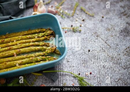Gerösteter Spargel, gewürzt mit Salz, Pfeffer, Knoblauch und mit frischen Kräutern verziert Stockfoto