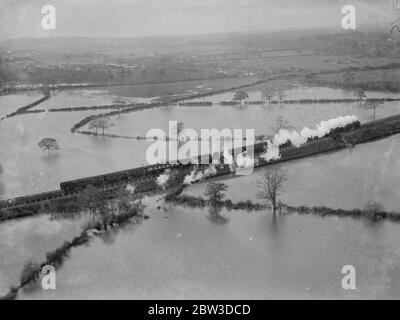 Dreizehn Dörfer in Kent, die von Überschwemmungen abgeschnitten sind. Ein Zug durch die überflutete Landschaft in der Nähe von Sevenoaks , Kent . 18. November 1935 Stockfoto