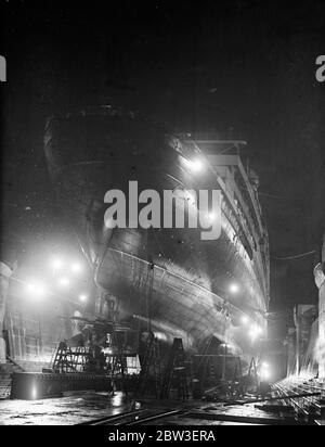 Eine nächtliche Ansicht der Tag und Nacht Arbeit, um die Schäden an der Ozeandampfer zu reparieren, Aquitania durch raue Meere gemacht. Bild zeigt ; die Aquitania im neuen Graviersteg in Southampton . 14. Januar 1935 Stockfoto