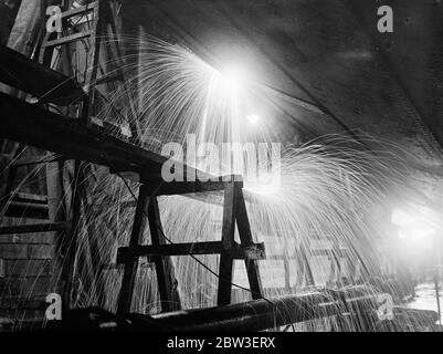 Eine nächtliche Ansicht der Tag und Nacht Arbeit, um die Schäden an der Ozeandampfer zu reparieren, Aquitania durch raue Meere gemacht. Bild zeigt ; Sparks fliegen, während die Schweißer auf die Aquitania in der neuen Gravierstation in Southampton gehen. 14. Januar 1935 Stockfoto