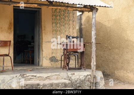 Afrika, Westafrika, Togo, Kpalime. Nähmaschine vor einem rustikalen Haus auf der Straße in Kpalimé. Stockfoto