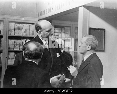 M Flandin wird bis nach Genf gesehen. Foto zeigt, M Flandin, Frankreich ' s großen Außenminister, überragt andere Delegierte, mit denen er im Völkerbund Palast in Genf spricht. März 1936 Stockfoto