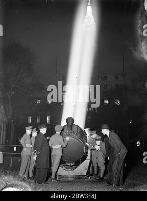 Suchscheinwerfer spielen über der Stadt Post-Office Gewehre Demonstration . Leistungsstarke Scheinwerfer über der Stadt gespielt, wenn die 7 City of London Regiment (Post Office Gewehre) gab eine Anti-Flugzeug-Demonstration in Finsbury Square, während ihrer Rekrutierungsfahrt. Das Regiment ist ein Anti-Flugzeug-Scheinwerfer Bataillon gebildet, um bei der Verteidigung von London zu helfen. Foto zeigt, Zivilisten, die während der Demonstration den Scheinwerfer inspizieren. 11 März 1936 Stockfoto