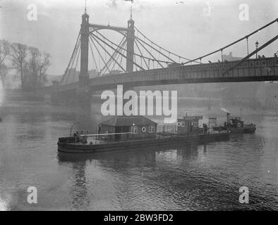 Der Cadogan Pier wird unter der Albert Bridge geschleppt. 22. Januar 1935 Stockfoto