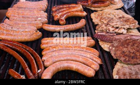 Saftige gegrillte Würstchen und Burger. Stockfoto