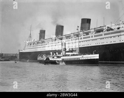 Königin Mary hat Besucher aus dem Osten. Tausende von Osterurlaubern nutzen die Gelegenheit, die der Urlaub bietet, um das neue Linienschiff Queen Mary in Southampton zu inspizieren. Die Lustdampfer bieten ausgezeichnete Grand Stände. Foto zeigt, Vergnügen Dampfer Passagiere bekommen eine Nahaufnahme der Queen Mary in Southampton. 11. April 1936 Stockfoto