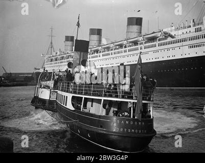 Königin Mary hat Besucher aus dem Osten. Tausende von Osterurlaubern nutzen die Gelegenheit, die der Urlaub bietet, um das neue Linienschiff Queen Mary in Southampton zu inspizieren. Die Lustdampfer bieten ausgezeichnete Grand Stände. Foto zeigt, Vergnügen Dampfer Passagiere bekommen eine Nahaufnahme der Queen Mary in Southampton. 11. April 1936 Stockfoto