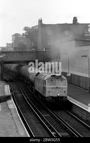 Baureihe 47 Diesellokomotive Nr. 47276 zieht Procor und Elf Tanks in Caledonian Road und Barnsbury Station, London, Großbritannien. September 1986. Stockfoto