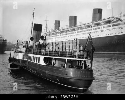 Königin Mary hat Besucher aus dem Osten. Tausende von Osterurlaubern nutzen die Gelegenheit, die der Urlaub bietet, um das neue Linienschiff Queen Mary in Southampton zu inspizieren. Die Lustdampfer bieten ausgezeichnete Grand Stände. Foto zeigt, Vergnügen Dampfer Passagiere bekommen eine Nahaufnahme der Queen Mary in Southampton. 11. April 1936 Stockfoto