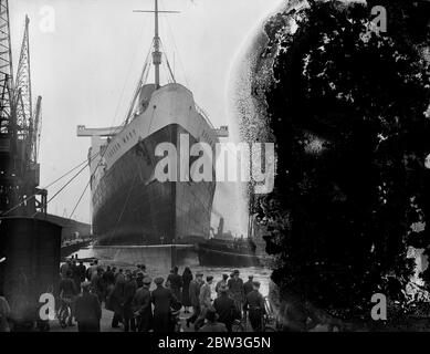 Queen Mary zog zum Meer gehen Liegeplatz von Southampton Trockendock. Der riesige Liner "Queen Mary" wurde von der King George V Graving Dock in Southampton, wo ihre Propeller geändert wurden und ihr Rumpf mit nicht korrosiven Farben beschichtet, zum Ocean Dock verschoben, Das Meer geht Liegeplatz sie besetzen, wenn sie in den Nordatlantik Dienst . Sie wird Southampton nächste Woche verlassen, um ihre Prozesse zu beenden. April 1936 Stockfoto