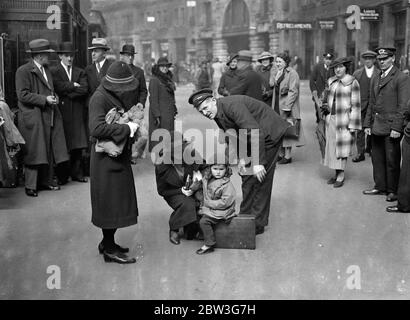 Warten auf den Urlaub Zug . Der große Bahnhof von London befindet sich jetzt auf dem Höhepunkt des Osterrausches. Tausende von Londonern verlassen die Metropole, um ein paar Tage im Land oder an Badeorten zu verbringen. Foto zeigt, zwei kleine Reisende in Waterloo diskutieren das Thema Urlaub mit einem Portier. 11. April 1936 Stockfoto