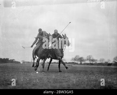 Englische Polo-Team Praxis in Aldershot für Spiele mit Amerika . Das englische Polo-Team, das Amerika in einer Reihe von Spielen für den Internationalen Polo Cup treffen soll, üben auf dem Ball Hill Polo Ground in Aldershot. Die Spiele sollen in diesem Sommer in Hurlingham stattfinden. Die Trophäe , eine der begehrtesten im Spiel , wird derzeit von Amerika gehalten . Foto zeigt, Kapitän Eric Tyrell Matin (Kapitän) (links) und Herr H H Hughes tragen "Chaps", Rennen für den Ball am Ball auf Ball Hill Polo Hügel in der Nähe von Aldershot. April 1936 Stockfoto