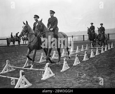 Kavallerie Proben für Royal Turnier . Ihre Reittiere über atemberaubende Sprünge entsatteln und die schwierigsten Meisterleistungen mit hervorragender Reitkunst durchführen, Proben Troopers der Equitation Sctool in Weedon, Northamptonshire, für das Royal Tournament, das im Olympia eröffnet, nächsten Monat. Die Männer, die teilnehmen, werden aus allen Kavallerieeinheiten der British Army ausgewählt. Foto zeigt, Kavalleristen ihre Pferde über niedrige Hürden nehmen, platziert nur wenige Zentimeter vom Boden, bei Weedon. 14. April 1936 Stockfoto