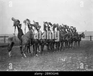 Kavallerie Proben für Royal Turnier . Ihre Reittiere über atemberaubende Sprünge entsatteln und die schwierigsten Meisterleistungen mit hervorragender Reitkunst durchführen, Proben Troopers der Equitation Sctool in Weedon, Northamptonshire, für das Royal Tournament, das im Olympia eröffnet, nächsten Monat. Die Männer, die teilnehmen, werden aus allen Kavallerieeinheiten der British Army ausgewählt. Foto zeigt, Kavalleristen zeigen ihre Sättel nach dem Absatteln über die Sprünge während einer Übungsfahrt in Weedon. 14. April 1936 Stockfoto