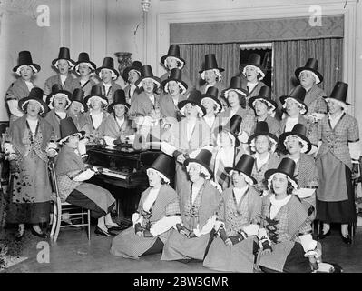 Der Chor der Royal Welsh Ladies Proben in London, bevor der World Song Up gespielt wird. Der Royal Welsh Ladies Choir, den Mme Clare Novelle Davies auf eine Gesangsreise durch die Welt nimmt, probt bei Mme Davies London zu Hause für ihre Tour. Die hofft, die Tour zu einer Mission des Friedens zu machen, besteht aus den brillantesten Sängern Wales produzieren kann. Viele von ihnen sind Töchter des ursprünglichen Welsh Choir, die eine Menge von 25 begeistert gehalten, 000 in Chicago im Jahr 1893. Auf ihrer Tour werden die Mädchen walisische Kostüme, hohe Hüte und Schnallschuhe tragen. Foto zeigt den Royal Welsh Ladies Chor rehe Stockfoto