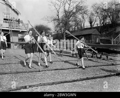 London University tragen Cambridge in Frauen Boot Rennen in Barnes. Die Mädchen der London University, die ihre Ruder herausnehmen. 21 März 1935 Stockfoto