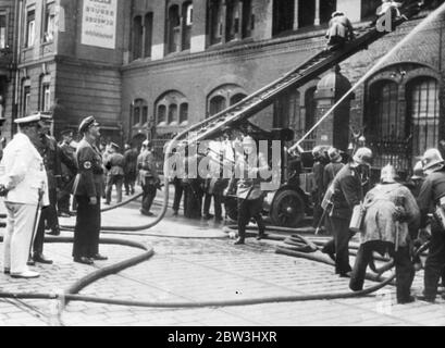 General Göring, preußischer Premier und Leiter des Preußischen Staatstheaters, stürzte sich in die Szene, als in den Werkstätten des Preußischen Staatstheaters, das an den berühmten Bahnhof Friedrichstraße in Berlin angrenzt, ein Feuer ausbrach. Fast die Hälfte der Berliner Feuerwehr mit Gasmasken, sowie Sonderkommandos von SS- und SA-Männern und Geheimpolizei wurden vor Ort gerufen. Das Feuer brach kurz nach der Ankunft der britischen und französischen Olympischen Teams aus und die Menschenmenge, die sich versammelten, um die Athleten zu begrüßen, geriet in Panik. Foto zeigt, General Göring (links weißen Anzug) mit Graf He Stockfoto