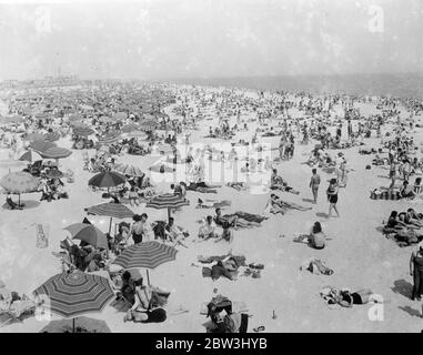 Erste Hitze - Wave Bilder Aus New York Thousand Seek The Cool Beaches . Sweumging unter der prallen Sonne, die den großen Bauernhof Gürtel in eine öde Abfälle verwandelt hat, strömen Tausende von New Yorker an die kühlen Strände der Stadt in dem Bemühen, der Hitze zu entkommen - Welle. Viele schlafen die ganze Nacht, aber andere, unfähig, weg von der Stadt zu bekommen, wurden gezwungen, auf den Dächern zu schlafen. Foto zeigt : der überfüllte Jones Beach auf Long Island als Tausende von New Yorkern Befreiung von der Hitzewelle suchten. Juli 1936, 13 Stockfoto