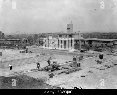 Chingford ' s Hügel Swimmingpool fast fertig. Chingford ' s neuen Swimmingpool in Larkswood ist kurz vor der Fertigstellung und wird von Sir Kingsley Wood, Minister für Gesundheit, in vierzehn Tagen Zeit eröffnet werden. Der Pool wird auf einem Gelände von sieben Hektar Wald gebaut. Da es auf der Seite eines Hügels liegt, mussten Tausende von Tonnen Erde entfernt werden. Seine Position gibt Schutz vor dem Wind und hat maximale Menge an Sonne. Der Bereich des Pools ist 2700 Quadratmeter groß und hat eine Schwimmlänge von 165 Fuß und eine Breite von 60 Fuß. Es verfügt über ein Café, Sonnenterrassen und Verwaltungsgebäude. Phot Stockfoto