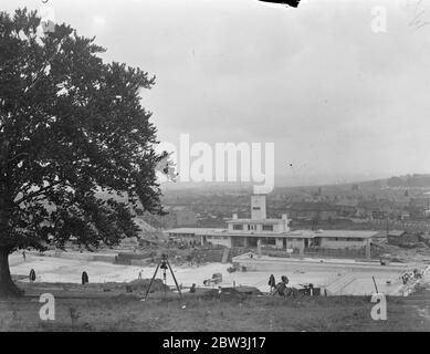 Chingford ' s Hügel Swimmingpool fast fertig. Chingford ' s neuen Swimmingpool in Larkswood ist kurz vor der Fertigstellung und wird von Sir Kingsley Wood, Minister für Gesundheit, in vierzehn Tagen Zeit eröffnet werden. Der Pool wird auf einem Gelände von sieben Hektar Wald gebaut. Da es auf der Seite eines Hügels liegt, mussten Tausende von Tonnen Erde entfernt werden. Seine Position gibt Schutz vor dem Wind und hat maximale Menge an Sonne. Der Bereich des Pools ist 2700 Quadratmeter groß und hat eine Schwimmlänge von 165 Fuß und eine Breite von 60 Fuß. Es verfügt über ein Café, Sonnenterrassen und Verwaltungsgebäude. Phot Stockfoto