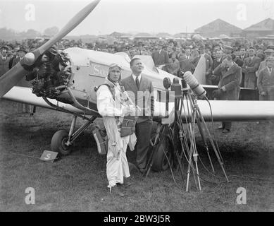 Birdman fliegt mit Flügeln auf Hanworth zur Erde. Clam Sohn, ein junger Amerikaner aus, Lansing Michigan, gab seine erste Ausstellung von "Vogel" Flug in großbritannien in Hanworth Air Park, Feltham, Middlesex. Einen Flügelanzug und eine Flosse an sich ziehen Sohn flog aus einer Höhe von etwa 10, 000 Fuß auf die Erde wie eine riesige Möwe. Er faltete seine Flügel und zog die Schnur eines Fallschirms, als er innerhalb von 1, 000 Fuß des Bodens, Foto zeigt Clem Sohn demonstriert die Wirkung seiner Flügel, um die Menge vor dem Aufsteigen. Mai 1936 Stockfoto