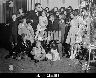 Henry Hall unterhält fünfhundert Kinder in Marble Arch. Henry Hall genießt einen Witz mit den Kindern. 27 Dezember 1935 Stockfoto