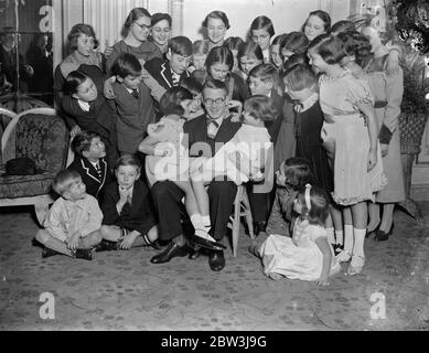 Henry Hall unterhält fünfhundert Kinder in Marble Arch. Henry Hall genießt einen Witz mit den Kindern. 27 Dezember 1935 Stockfoto