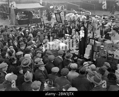 Weihnachtsstimmung auf dem kaledonischen Markt. Caledonian Markt, einer der berühmtesten Schnäppchen Zentren Londons ist in der Mitte seiner weihnachtszeit. Foto zeigt, ein Puppenverkäufer in Aktion auf dem kaledoonischen Markt. 13 Dezember 1935 Stockfoto