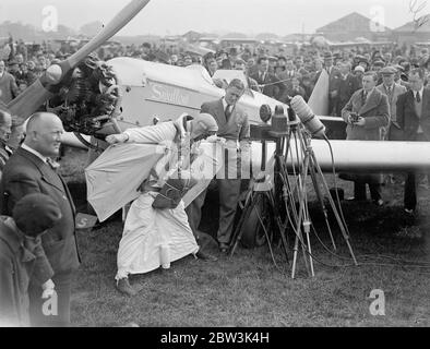 Birdman fliegt mit Flügeln auf Hanworth zur Erde. Clam Sohn, ein junger Amerikaner aus, Lansing Michigan, gab seine erste Ausstellung von "Vogel" Flug in großbritannien in Hanworth Air Park, Feltham, Middlesex. Einen Flügelanzug und eine Flosse an sich ziehen Sohn flog aus einer Höhe von etwa 10, 000 Fuß auf die Erde wie eine riesige Möwe. Er faltete seine Flügel und zog die Schnur eines Fallschirms, als er innerhalb von 1, 000 Fuß des Bodens, Foto zeigt Clem Sohn demonstriert die Wirkung seiner Flügel, um die Menge vor dem Aufsteigen. Mai 1936 Stockfoto