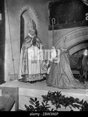 Boy Bischof thront in der ersten öffentlichen Zeremonie seit der Reformation in Guilford . Fred Brazier, im Alter von 12 als "Boy Bishop" von St. Mary of the Angels Song School, Highgate, wurde von der Rev Desmond Morse Boykott als St. Nicholas inthronisiert, in Compton Kirche, Guilford, Surrey, In der ersten öffentlichen Zeremonie seit der Reformation . Foto zeigt, der Junge Bischof, Fred Krasier im Alter von 12 Jahren, wird von der Rev Desmond Morse Boykott als St. Nicholas inthronisiert. Dezember 1935 Stockfoto