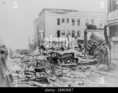 Hunderte Tote und Verletzte, während Tornado Südamerika zerstört. Die Szene der Zerstörung im Herzen von Gaineaville, Georgien, eine der Städte, die am meisten in den Tornado gelitten. Autos stehen in der Mitte der Straße, wo sie von verängstigten Fahrer verlassen wurden, um von den Schutt-Haufen von zerstörten Gebäuden zerschlagen werden. 15. April 1936 Stockfoto